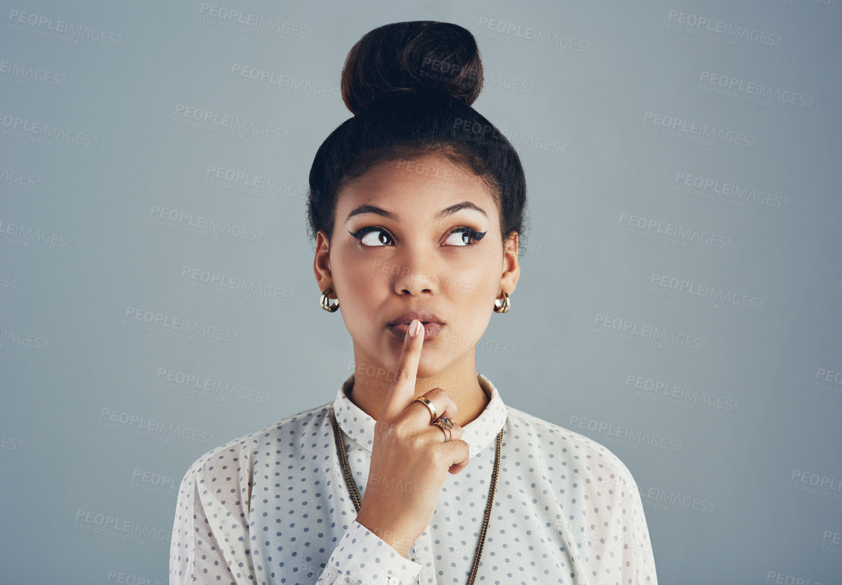 Buy stock photo Studio shot of an attractive young woman posing against a gray background