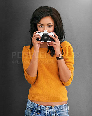Buy stock photo Studio shot of a young woman using a vintage camera against a gray background