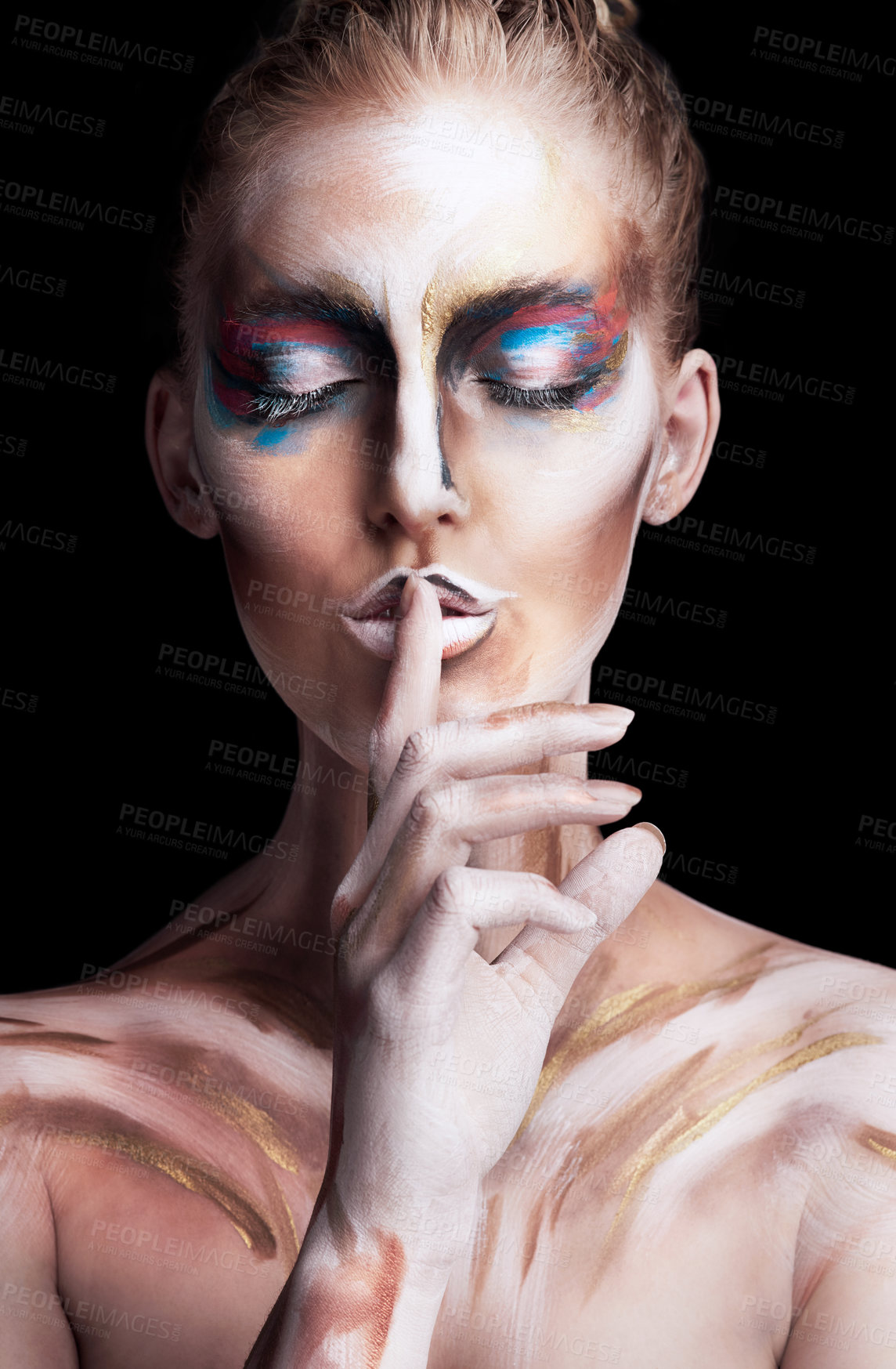 Buy stock photo Studio shot of a young woman posing with paint on her face isolated on black