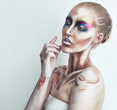 Buy stock photo Studio shot of a young woman posing with paint on her face