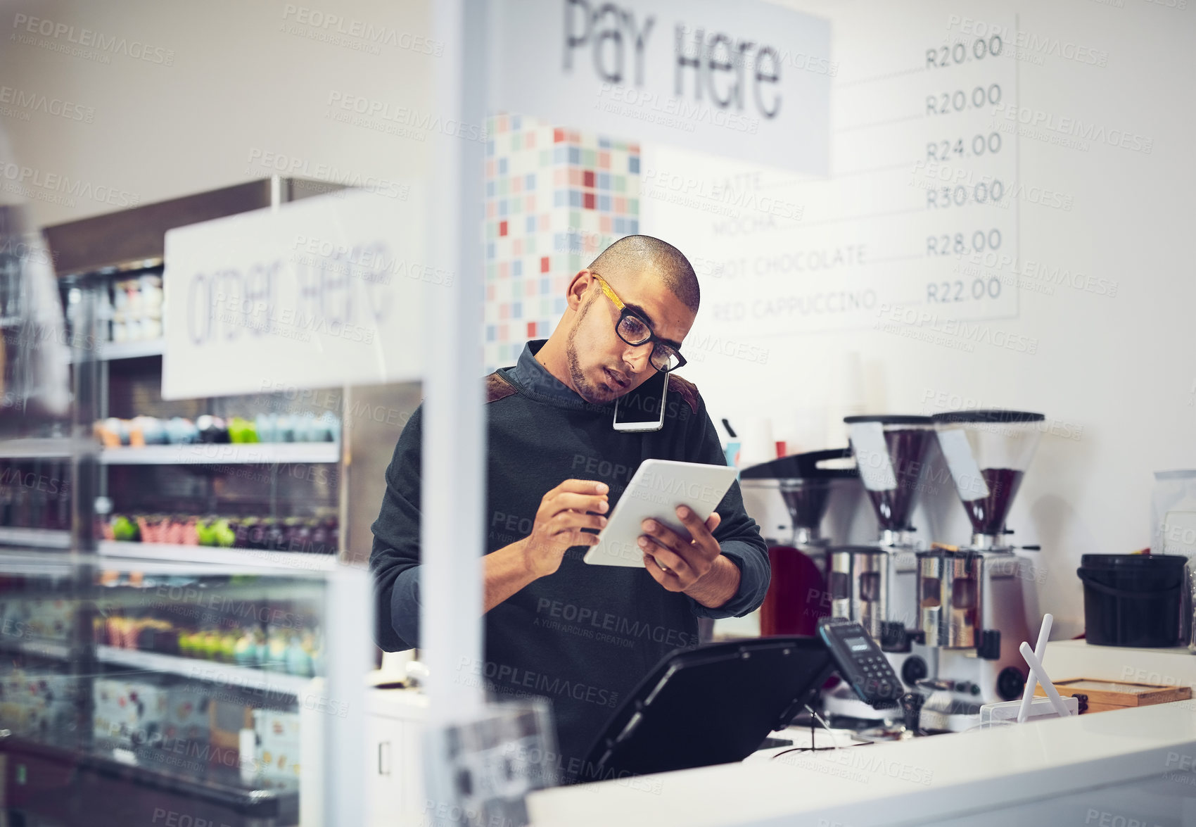 Buy stock photo Businessman, multitasking and phone call with tablet for order, online enquiry or purchase at coffee shop. Man, waiter or barista with mobile smartphone or technology for customer service at cafe