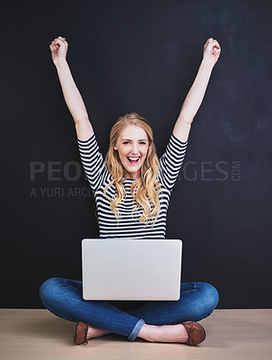 Buy stock photo Portrait of a young woman using a laptop against a dark background
