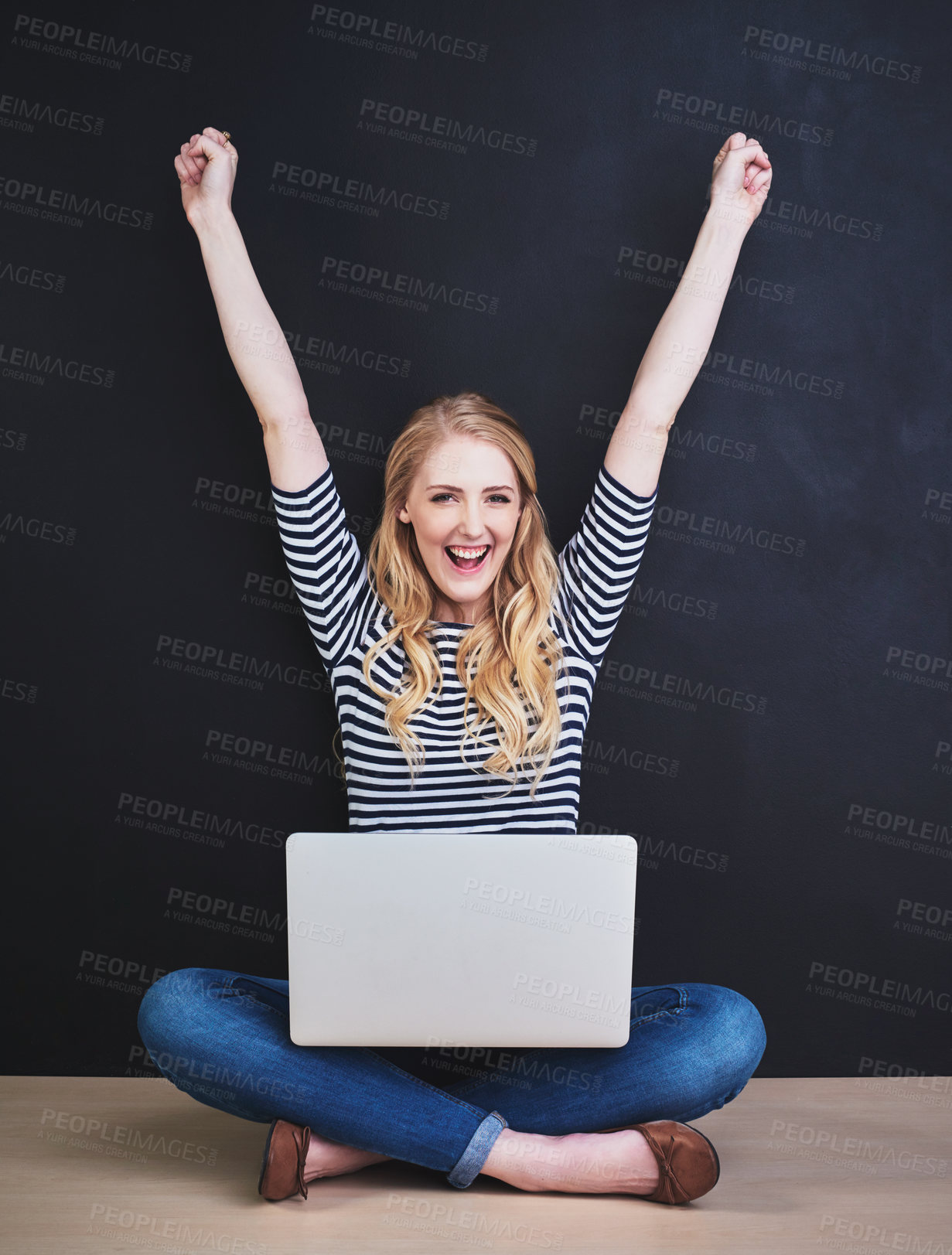 Buy stock photo Portrait of a young woman using a laptop against a dark background