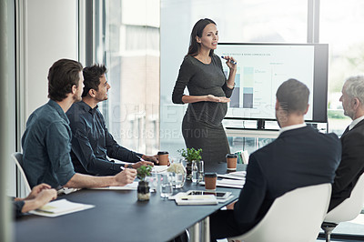 Buy stock photo Shot of a pregnant businesswoman giving a presentation on a monitor to colleagues in an boardroom