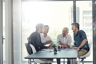 Buy stock photo Shot of a group of businessmen having a meeting around a table in an office