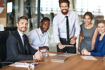Buy stock photo Portrait of a group of corporate colleagues working together on a digital tablet in an office