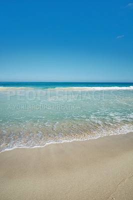 Buy stock photo Ocean waves washing onto an empty beach shore in a tropical resort with clear blue sky and copyspace. Calm and peaceful landscape to enjoy in summer for a relaxing holiday abroad or vacation overseas