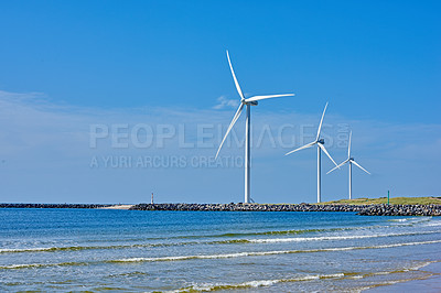 Buy stock photo Outdoor, ocean and wind turbine for green power, sustainability and renewable energy in nature. Beach, eco and infrastructure by sea with carbon capture and system for clean electricity generation