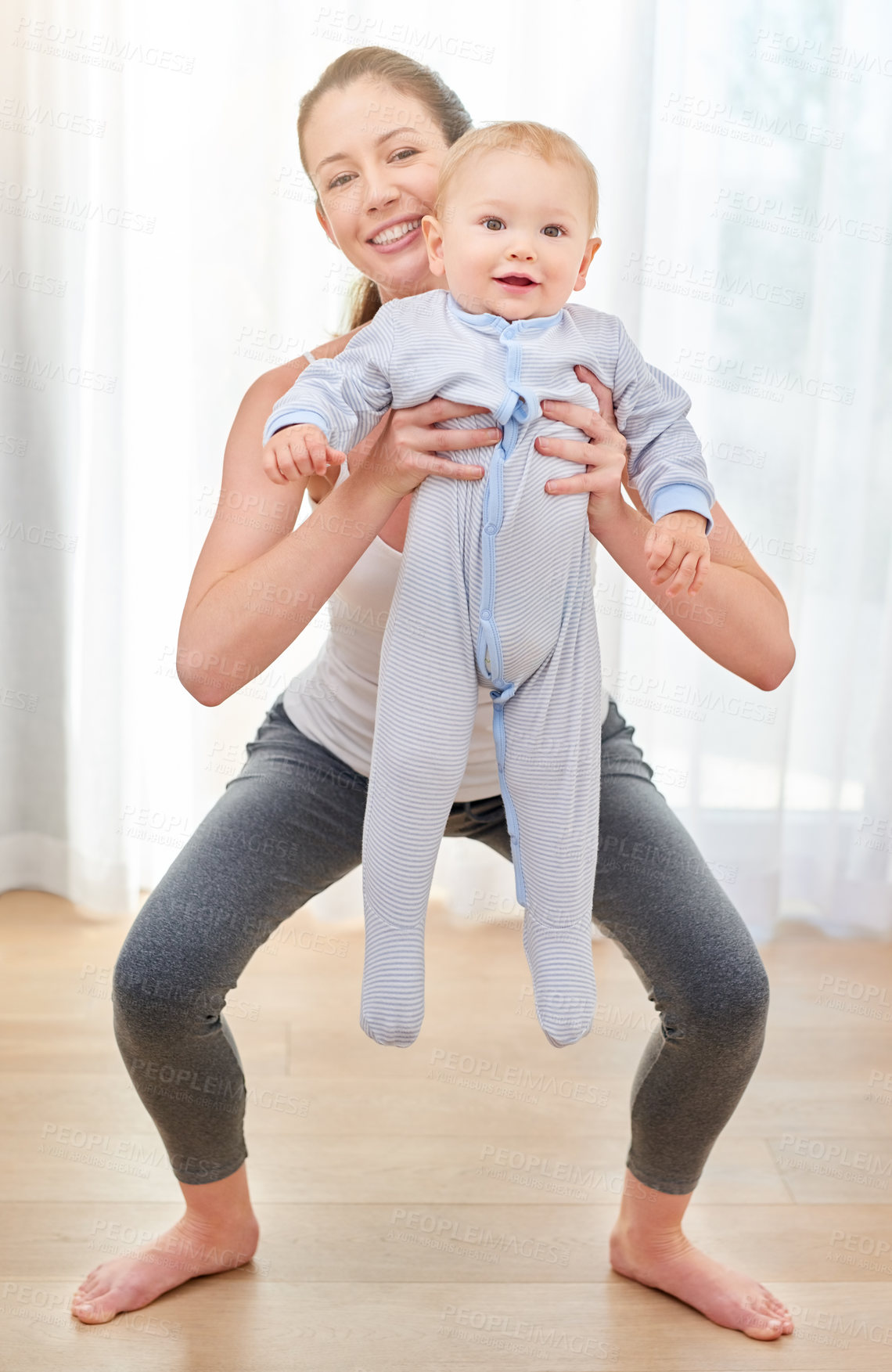 Buy stock photo Shot of a young woman working out while spending time with her baby boy