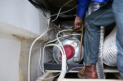 Buy stock photo Cropped shot of a handyman repairing a pipe on a water heater