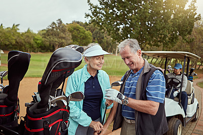 Buy stock photo Shot of a senior couple choosing their clubs while enjoying a day on the golf course