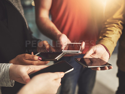 Buy stock photo Shot of a group of colleagues using their cellphones in an office