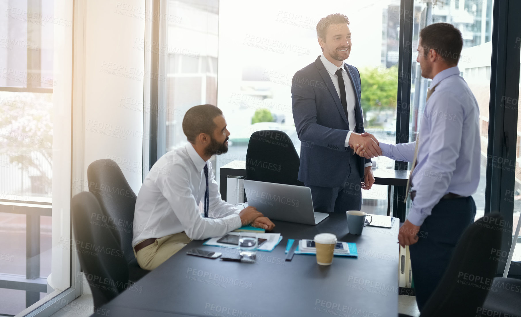 Buy stock photo Cropped shot of two businessmen shaking hands while in a meeting