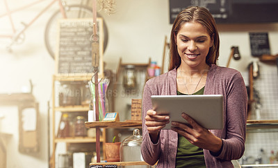 Buy stock photo Shot of a young entrepreneur using a digital tablet in her store
