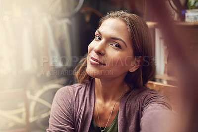 Buy stock photo Shot of an attractive young woman taking a selfie in a store