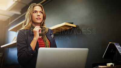 Buy stock photo Cropped shot of a young business owner using a laptop in her shop