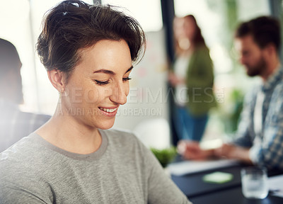 Buy stock photo Cropped shot of a young businesswoman sitting in a modern office with her colleagues