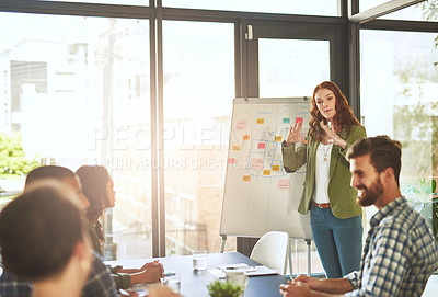 Buy stock photo Cropped shot of a young woman giving a presentation to her coworkers in a modern office