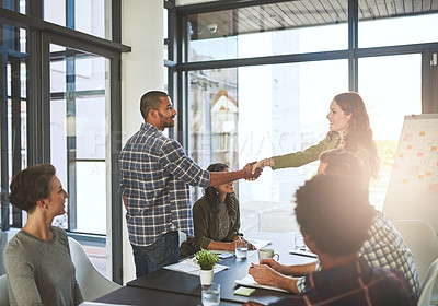 Buy stock photo Cropped shot of businesspeople shaking hands in a modern office