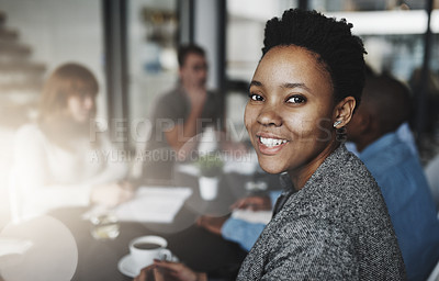Buy stock photo Portrait of a young businesswoman sitting in an office with colleagues in the background