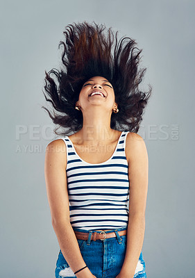 Buy stock photo Shot of a carefree young woman posing against a grey background