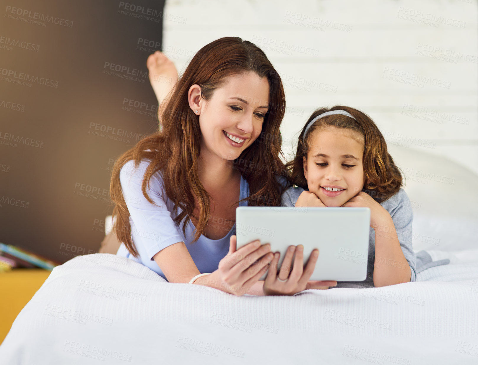 Buy stock photo Full length shot of a mother and her daughter using a digital tablet