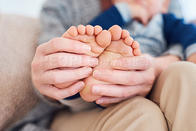 Buy stock photo Mommy, baby and feet for love in home, security and support in bonding for wellness or trust. Mother, toddler and care for maternity or relax on couch, child development and comfort for single mom