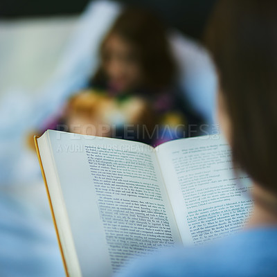Buy stock photo Blurred shot of a mother reading a bedtime story to her daughter