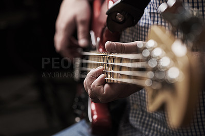 Buy stock photo Cropped shot of an unrecognizable man playing an electric guitar at home