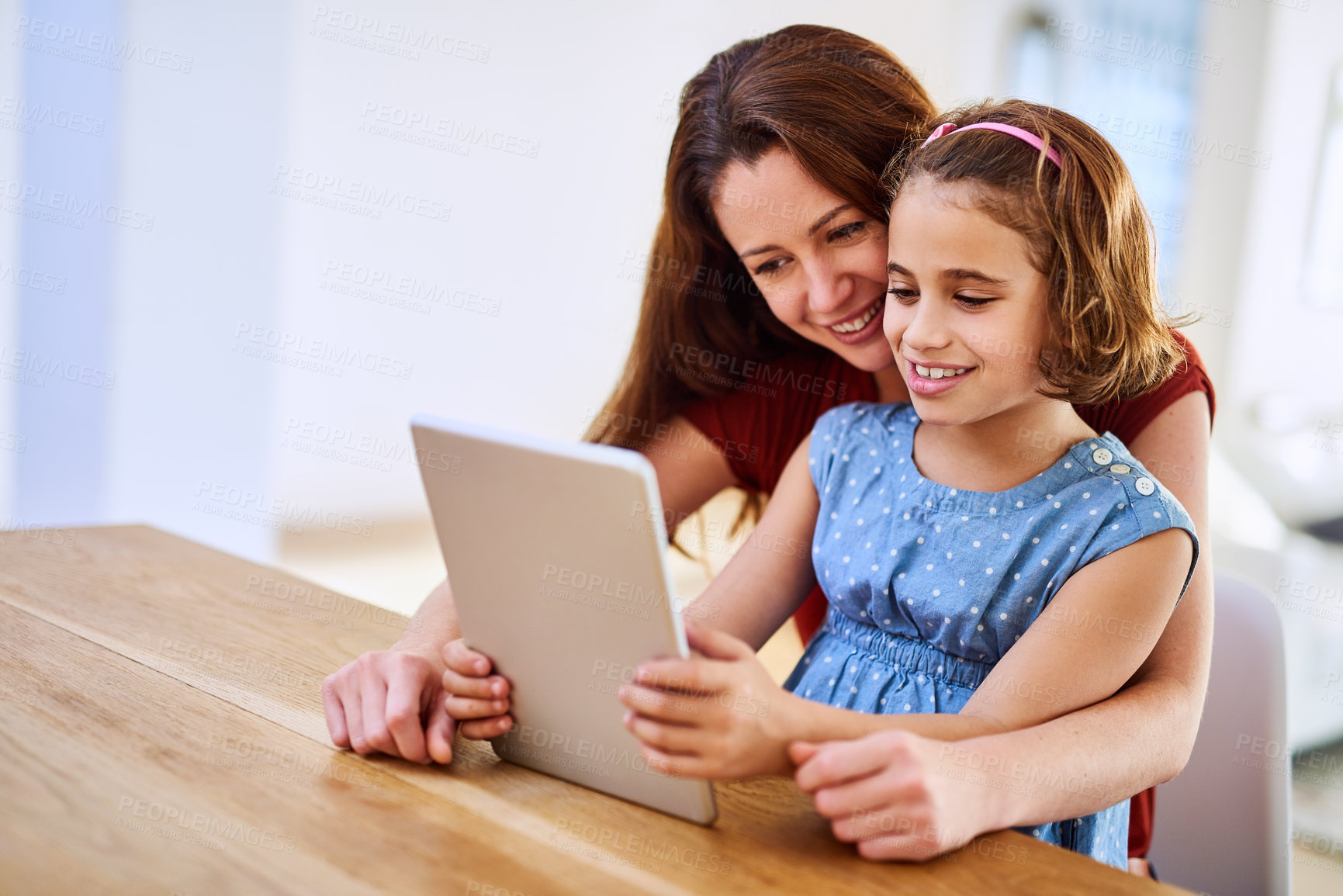 Buy stock photo Cropped shot of mother and daughter using a digital tablet together at home