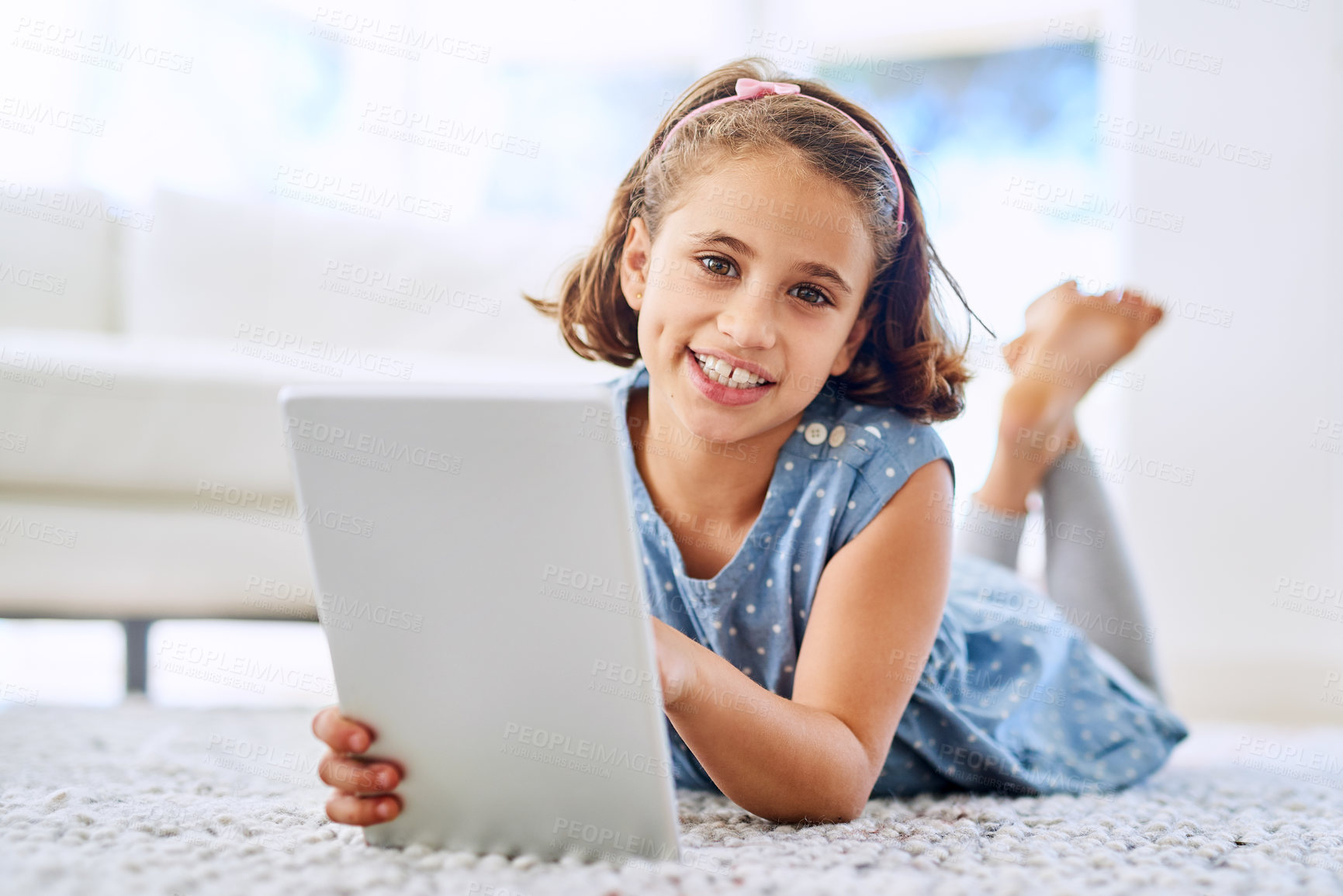 Buy stock photo Portrait, tablet and happy girl child in house for game, show or streaming movie online in living room in Spain. Face, smile or kid on digital tech in lounge for learning, education or relax on floor