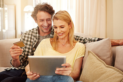 Buy stock photo Cropped shot of a loving couple shopping online on their tablet