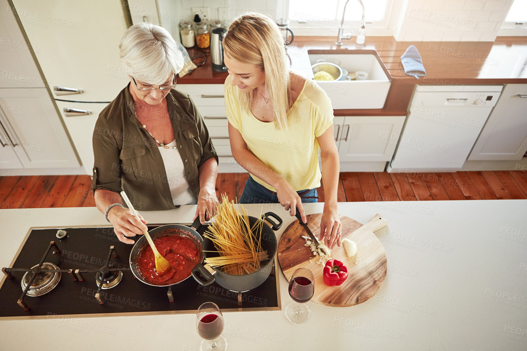 Buy stock photo Above, woman or mother cooking food for a healthy vegan diet together with love in a happy family home. Girl, spaghetti or adult child helping senior mom in house kitchen for lunch meal or dinner 