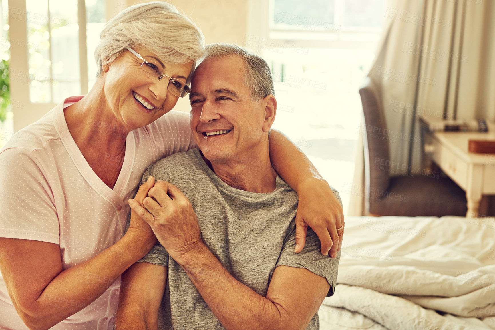 Buy stock photo Cropped shot of a senior couple embracing in their bedroom