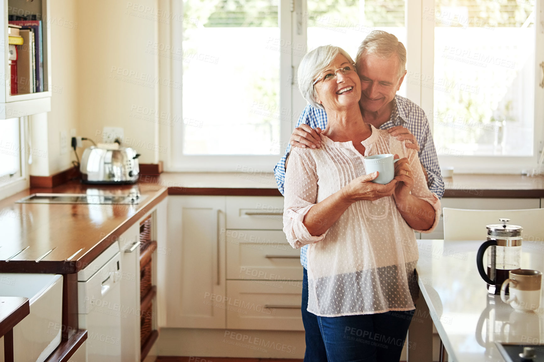 Buy stock photo Hugging, coffee or old couple laughing in kitchen at home bonding or enjoying quality time together. Embrace, retirement or happy mature man talking, relaxing or drinking tea with funny senior woman