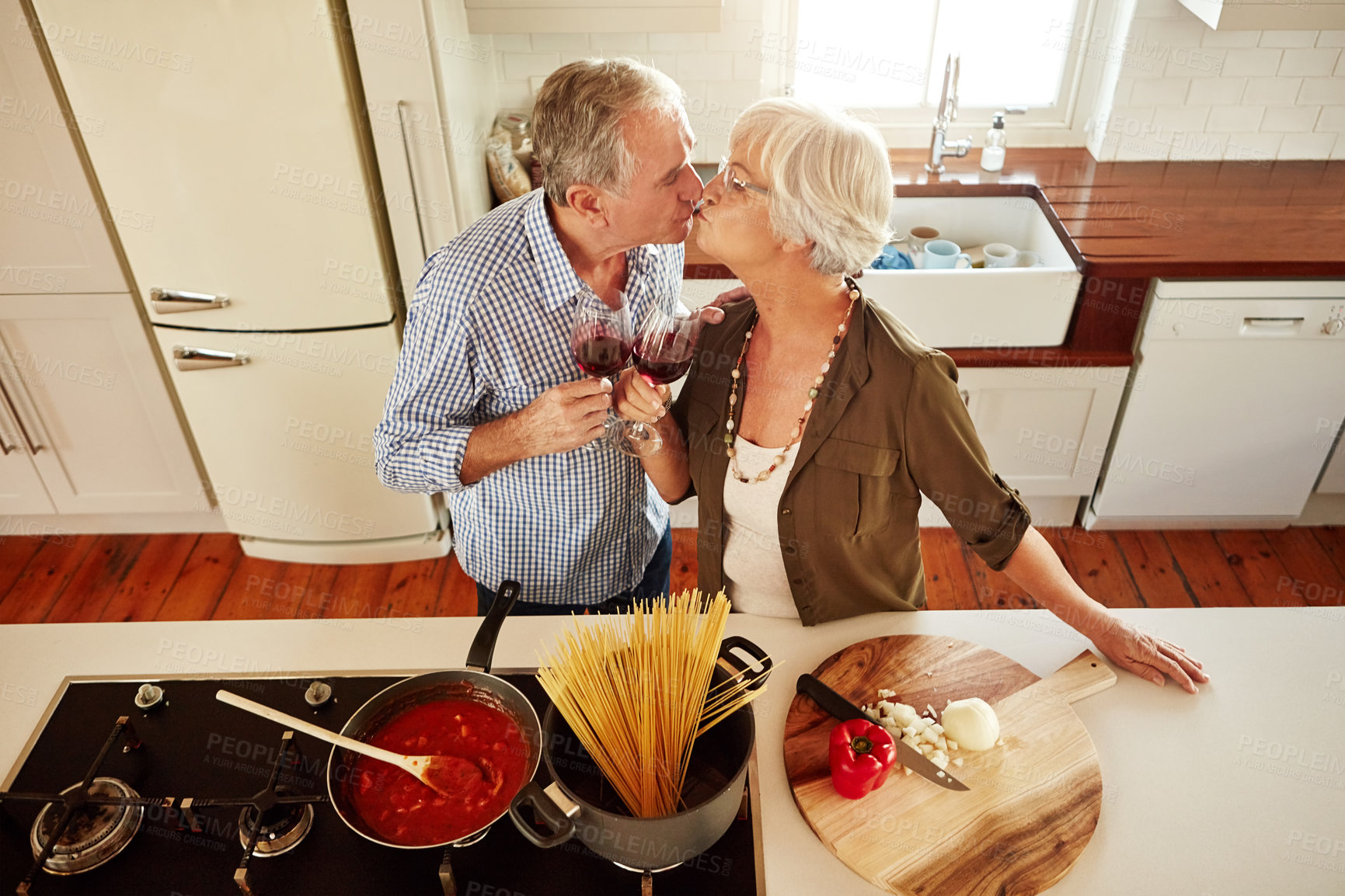 Buy stock photo Kiss, wine toast or old couple cooking food for a healthy vegan diet together with love in retirement at home. Top view of senior woman drinking or kissing in kitchen with mature husband at dinner 