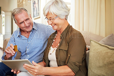 Buy stock photo Cropped shot of a senior couple shopping online on their tablet