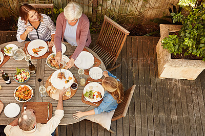 Buy stock photo Table, family and children at outdoor lunch for bonding, thanksgiving celebration or people eating in backyard. Men, women and kids at picnic on patio with food, grandparents and sharing from above