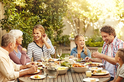 Buy stock photo Shot of a family eating lunch together outdoors