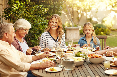 Buy stock photo Shot of a family eating lunch together outdoors