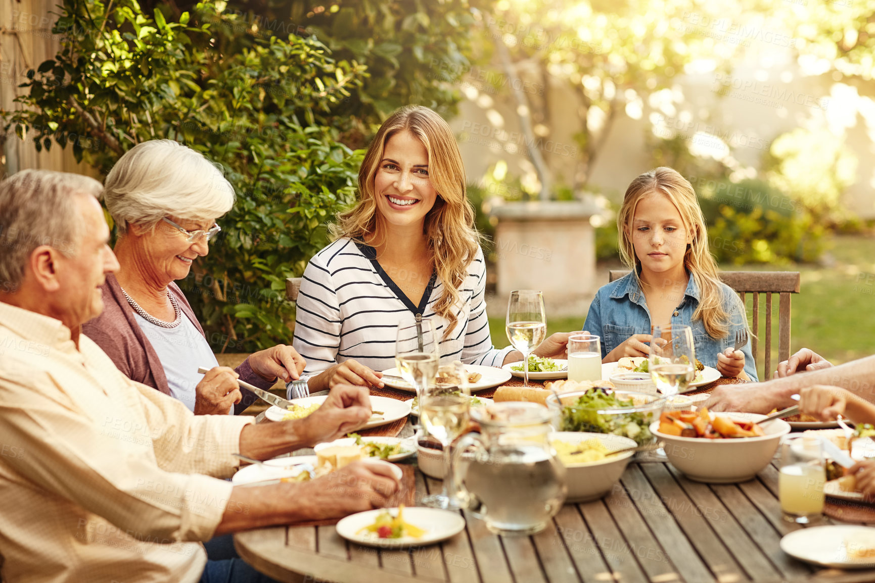 Buy stock photo Woman, love and food with family in nature for thanksgiving event, health and happiness. Bonding, support and celebration with group of people in garden of home for brunch, wellness or nutrition 
