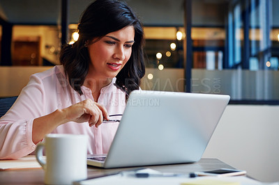 Buy stock photo Shot of a smiling businesswoman working on a laptop in an office