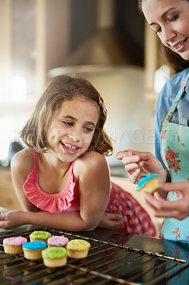 Buy stock photo Mother, child and cupcakes baking in kitchen or icing dessert as decoration, learning or bonding. Woman, daughter and teaching in home for sweets snack or happiness kid for recipe, helping or candy