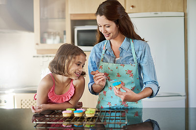 Buy stock photo Mother, child and icing cupcakes for baking in home or dessert decorations, learning or bonding. Woman, daughter and teaching at kitchen counter for sweets snack or development, helping or recipe