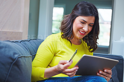 Buy stock photo Shot of a woman using her tablet and credit card at home