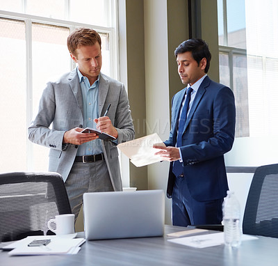 Buy stock photo Cropped shot of businessmen looking at paperwork in their office