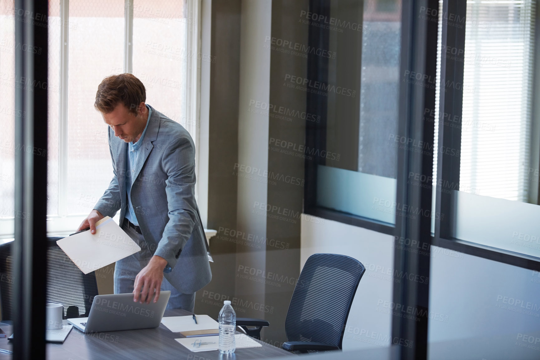 Buy stock photo Cropped shot of a businessman looking at paperwork in his office