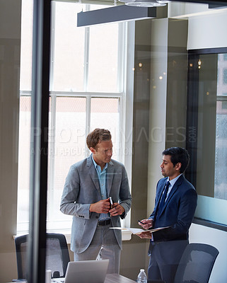 Buy stock photo Cropped shot of businessmen looking at paperwork in their office