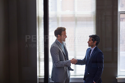 Buy stock photo Cropped shot of two businessmen shaking hands in the office