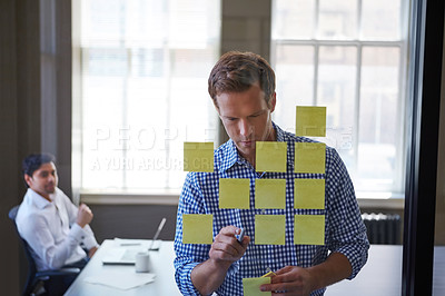 Buy stock photo Cropped shot of two businessmen preparing for a presentation by using adhesive notes